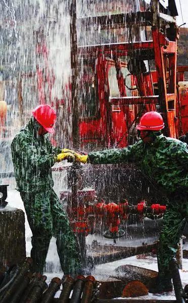 陕西延长石油集团职工冒雨工作场景。资料照片