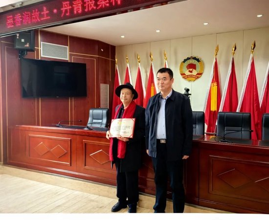 △武功县政协秘书长汪武刚（右）为捐赠人李众斌颁发捐赠证书