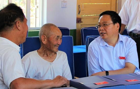 宜君县委书记刘冲与哭泉镇南塔村老党员交流。