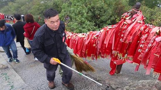 杜小利在華山西峰頂撿游客丟棄的垃圾。