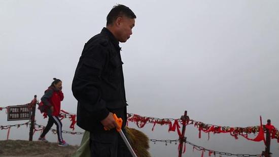 杜小利在華山西峰頂撿游客丟棄的垃圾。