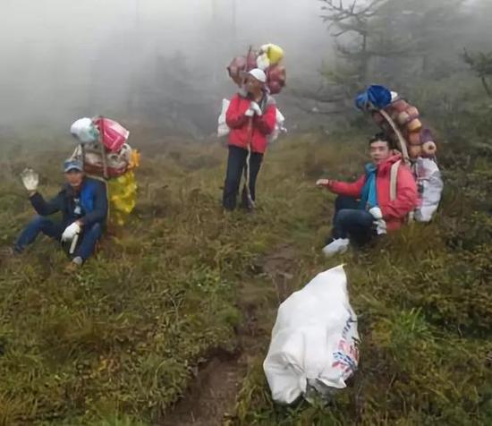 保護(hù)區(qū)工作人員清理垃圾并背下山