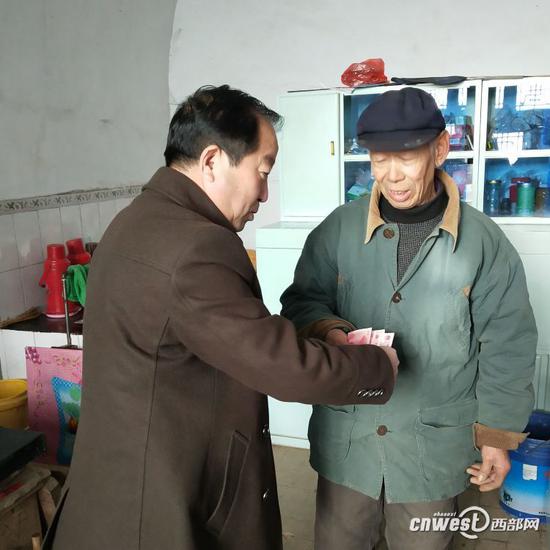 薛毅（左一）生前看望困難群眾。