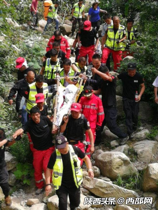 王某正在被抬下山。
