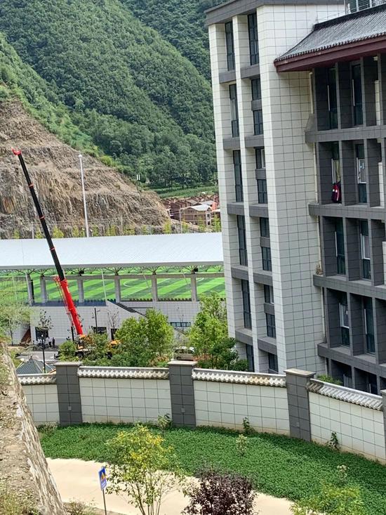 8月24日中午,镇安中学新校区正门紧锁,有挖掘机、渣土储车出入学校,喷泉、凉亭等设施正在被拆除。