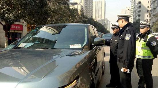 资料图:西安交警正在纠正违法占道停车。