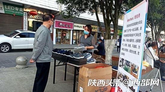王女士在紫阳县广场摆摊卖鞋。