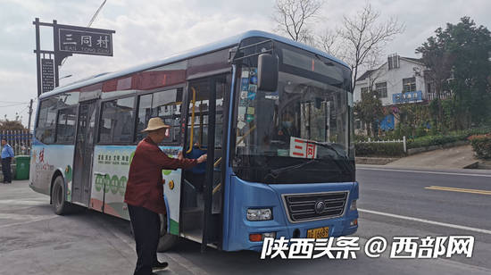 市民在汉阴县双乳镇三同村乘坐公交车