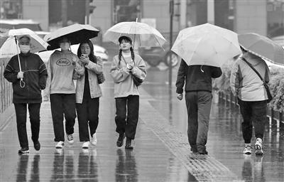 雨中出行的市民 本報記者 代澤均 攝