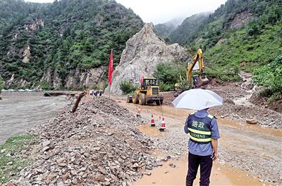 8月7日，工程机械在洛南县石门镇抢修疏通水毁道路。 本报记者 母家亮 摄