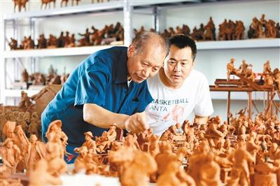 民间艺人苗春生和徒弟胡振波创作的大型泥塑作品《七十二行》 记者 黄亚平 摄