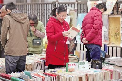 市民在路边的旧书摊上“淘宝” 本报记者 王晓峰 摄