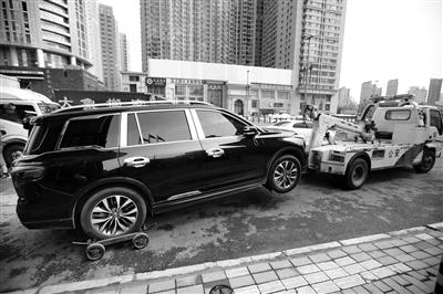“蹭停”车辆被拖移 本报记者 陈飞波 摄