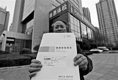 王女士的丈夫向记者出示体检报告 本报记者 王晓峰 摄