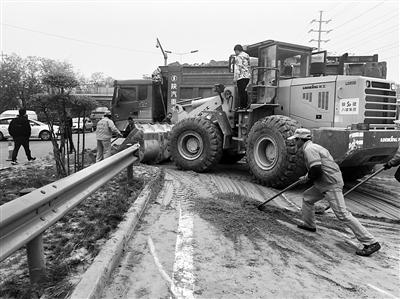 工作人员清理路面沙土