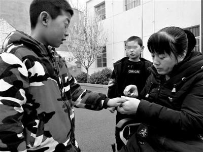 课余时间,张小侠坐着轮椅帮智障学生修剪指甲。(资料翻拍)