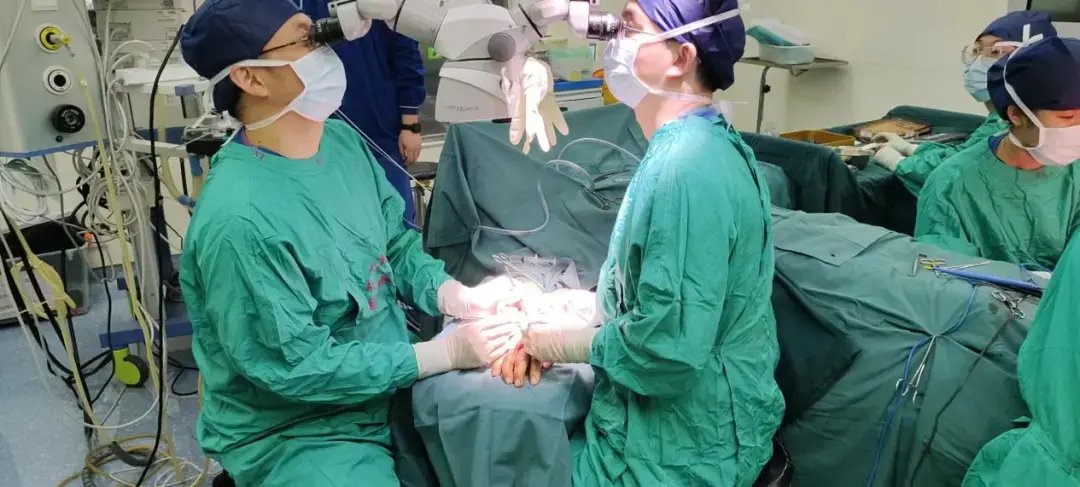 何林医师和张卓医师在显微镜下为患者行乳房重建手术