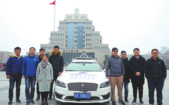 2月19日，陈仕韬（右四）及其团队成员在西安交通大学四大发明广场实地测试“先锋号”智能车。
