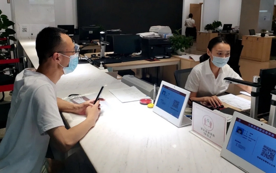 窗口工作人员延长办公时间,为群众办理相关的业务