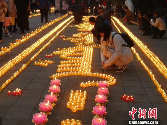 图为活动现场点亮酥油灯的西安民众。 党田野 摄