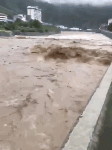 视频显示，受暴雨影响，县城河道水流湍急，水位暴涨。