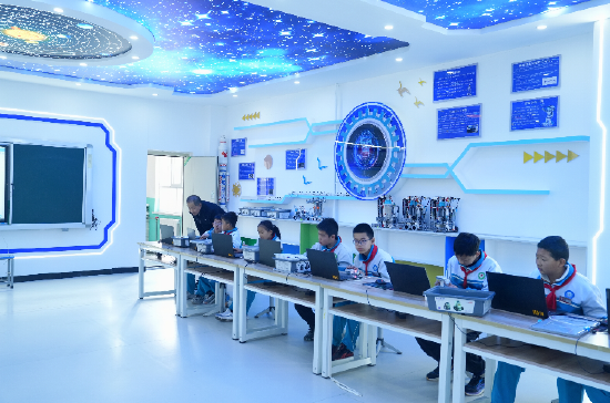 “机器人教学”是府谷县明德小学的特色课程，该校这几年来多次参加省级、国家级乃至世界级机器人竞赛，取得优异成绩。图为4月8日老师在“机器人课”上指导学生。记者王晨曦摄