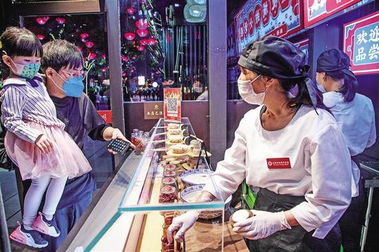 小店里各种口味的镜儿糕,吸引了众多游客前来购买。