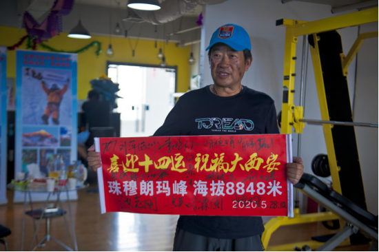 图为登顶珠穆朗玛峰的14人为十四运加油签名标语