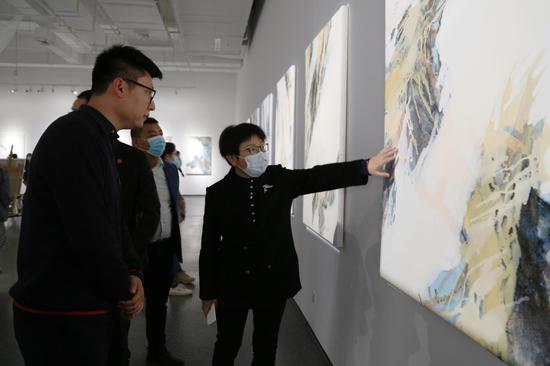 艺术家霍东泽为西安培华学院建筑与艺术设计学院常务副院长徐莹介绍作品