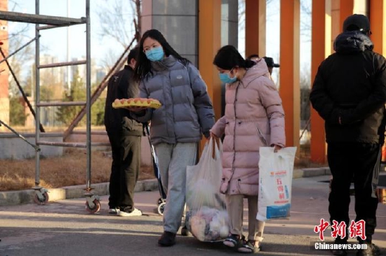 圖為居民領取蔬菜等物資。 張遠 攝