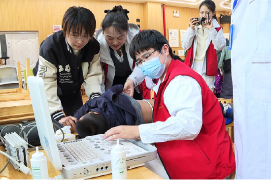 图为医生为当地学生进行超声检查诊断