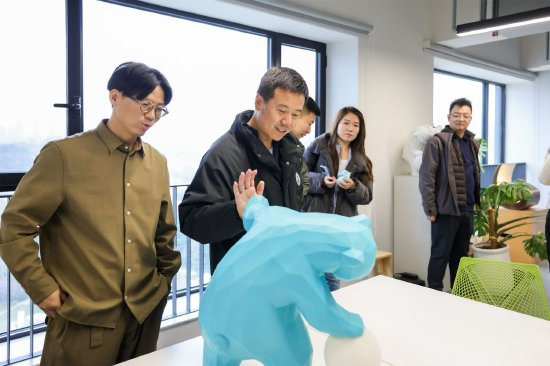 公共艺术家黄飞春（左一）讲解设计作品