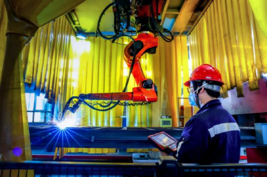 图为检修工操作智能焊接机器人作业