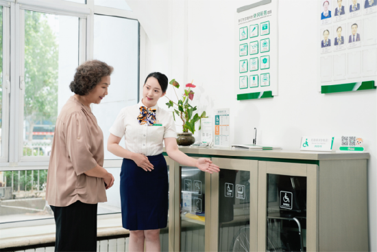 图：柜面服务人员为老年客户介绍适老化服务设施