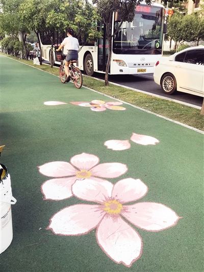 近日，明光路1.4公里自行车道被手绘的树叶花卉装扮得充满情调。 首席记者 赵丽莉 摄