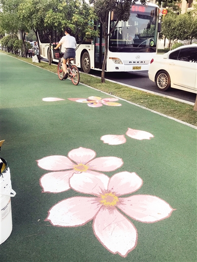 近日,明光路1.4公里自行车道被手绘的树叶花卉装扮得充满情调。 首席记者 赵丽莉 摄