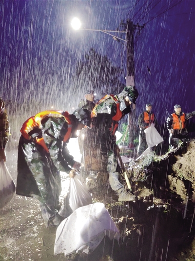 7月21日,驻扎在开封地区的空降兵某旅官兵冒雨在贾鲁河祥符区段加固堤坝。 新华社发