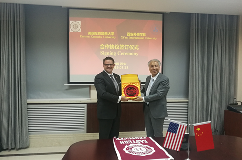 图:西安外事学院董事长黄藤(右)代表学校向东肯塔基大学校长Michael Benson(左)赠送礼物