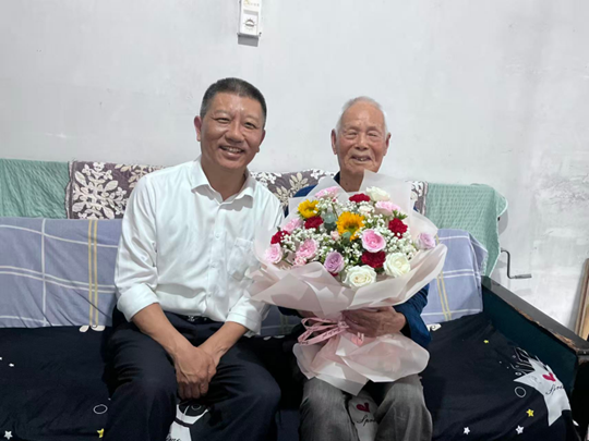 党委书记刘予东慰问退休教师许新安（右）