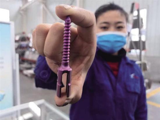 宝鸡鑫诺新金属公司是国内医药钛材的主要生产企业。图为工作人员展示医用钛骨钉。本报记者 刘强摄