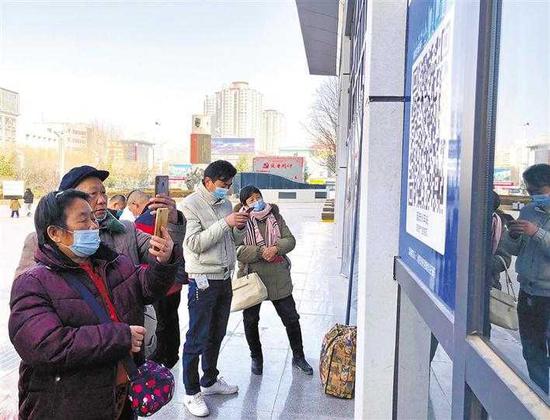 乘客在延安火車站進站口掃描“陜西健康碼”。 記者 劉印 攝