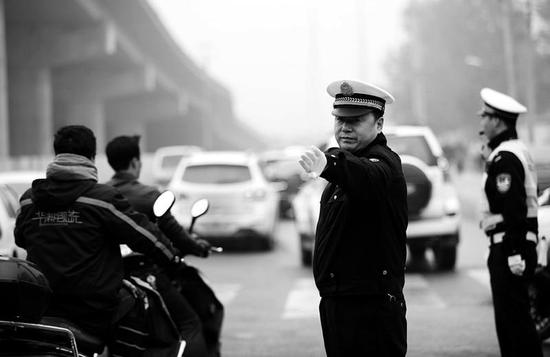 姚利军在北二环朱宏路立交桥下疏导交通 实习记者陈飞波摄