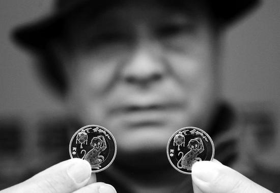 市民展示預(yù)約購得的猴年紀(jì)念幣 本報(bào)記者丁聘攝