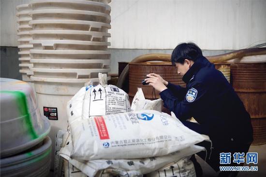 民警荣光辉在对收缴的制毒工具和原料留存取证