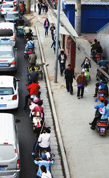 “摩的”在車流中任意穿梭,給乘客和自身帶來安全隱患