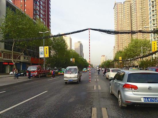 一根用以支撑电线的直杆立在西影路道路中央。 本报记者 朱剑摄