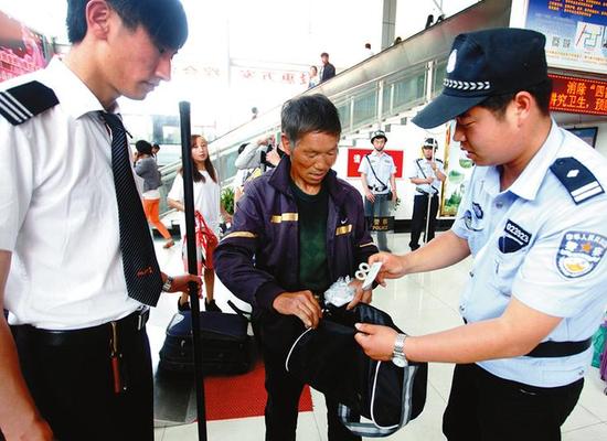 客运站工作人员检查旅客是否带有违禁品    本报记者代泽均摄