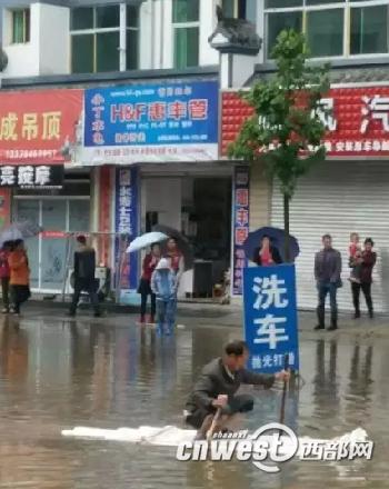 持续降雨致石泉城区古堰段“内涝” ，群众自制小船出行。