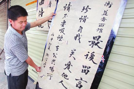 李政衡在剛轉(zhuǎn)出的店門(mén)口掛 禁煙牌子 本報(bào)記者代澤均攝