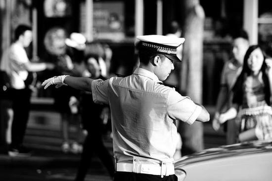 高温炎热西安街头一位交警后背被汗水湿透本报记者王晓峰摄